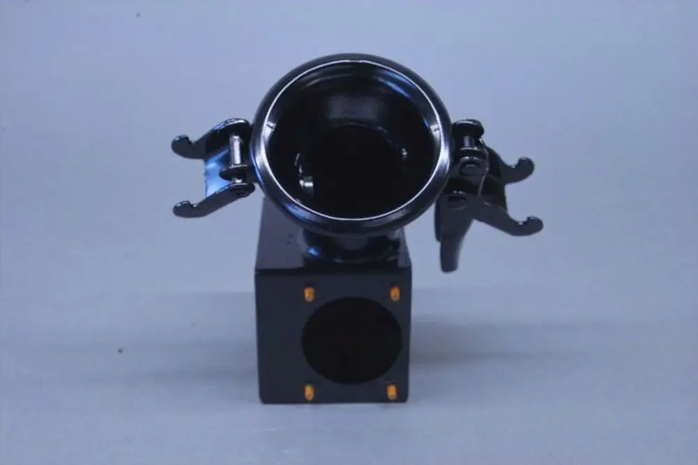 Schwarzes Bauteil mit einer runden Öffnung und zwei seitlichen Clips. Gehäuse mit quadratischem Grundriss. Produkt von Brötje zur Verbindung oder Übergabe.