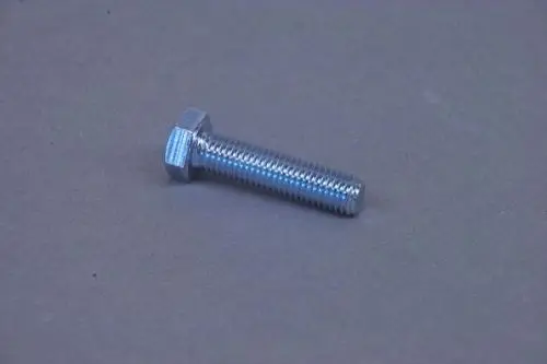 Brötje Stellfuß in metallischer Optik, mit einem hexagonalen Kopf und geriffeltem Schaft zur Fixierung. Liegt auf grauem Hintergrund.