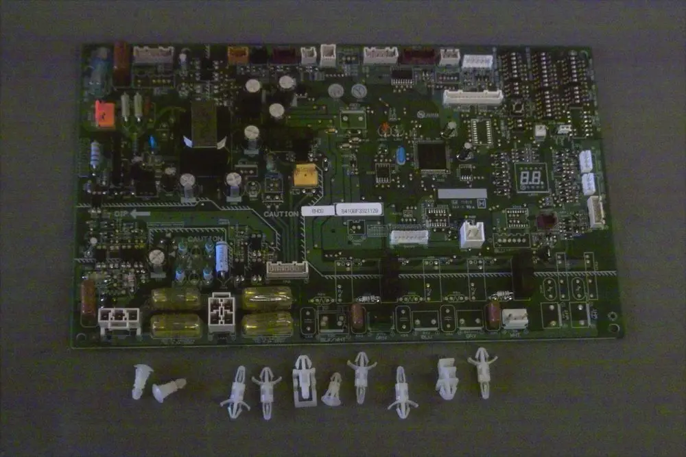Grüne Leiterplatte von Brötje mit verschiedenen elektronischen Komponenten, Steckplätzen und Display, umgeben von mehreren kleinen Halterungen.
