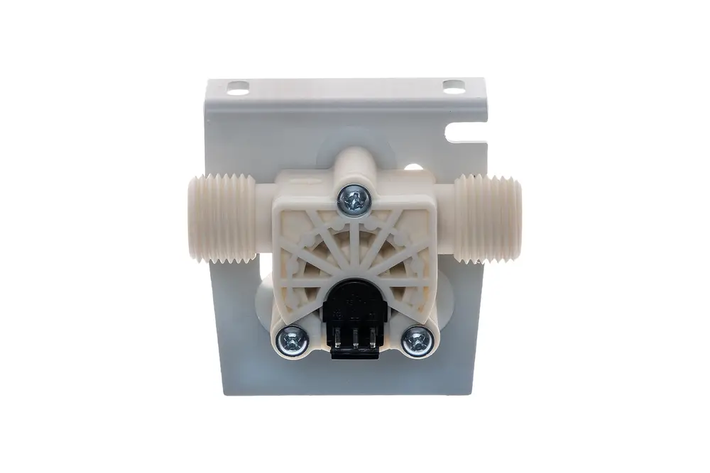 Durchflusssensor von Brötje in heller Kunststoffausführung. Mit zwei Gewindeanschlüssen und einem elektrischen Anschluss unten. Montiert auf einer flachen Halterung.