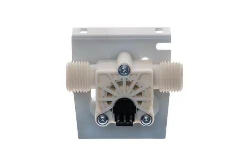 Durchflusssensor von Brötje in heller Kunststoffausführung. Mit zwei Gewindeanschlüssen und einem elektrischen Anschluss unten. Montiert auf einer flachen Halterung.