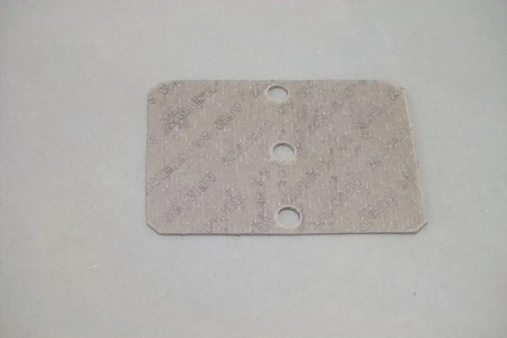 Dichtung aus grauem Material mit drei Löchern, möglicherweise zur Verwendung in Brötje-Produkten, auf einer neutralen Hintergrundfläche.