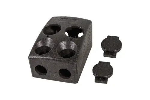 Isolierblock von Brötje mit vier Aussparungen und zwei Abdeckungen, schwarzes Material, klare Struktur.