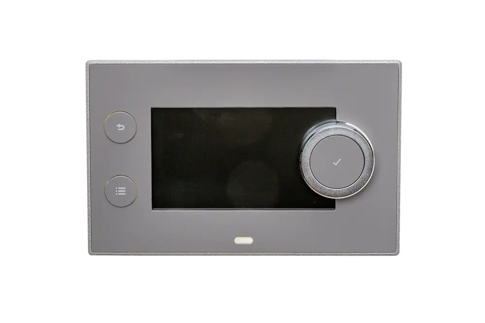 Bedienelement von Brötje mit einem Touchscreen und mehreren Tasten, darunter eine Rücktaste und ein Auswahlrad auf der rechten Seite, auf einem neutralen Hintergrund.
