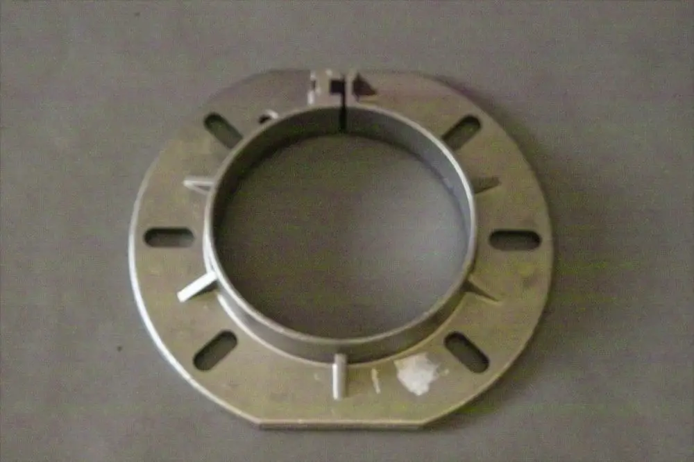 Metallischer Kesselflansch von Brötje mit runder Form und mehreren Ausstanzungen zur Montage. Der Flansch hat eine zentrale Öffnung und eine teilbare Konstruktion.