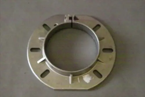 Metallischer Kesselflansch von Brötje mit runder Form und mehreren Ausstanzungen zur Montage. Der Flansch hat eine zentrale Öffnung und eine teilbare Konstruktion.