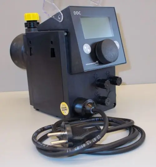 Brötje Dosierpumpe in kompaktem Design mit digitalem Display, mehreren Einstellknöpfen und Anschlusskabel. Vorderansicht mit sichtlichem Stecker.