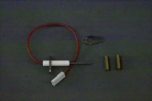 Brötje Ionisationselektrode mit einem weißen Kunststoffgehäuse und rotem Kabel, flankiert von zwei Messinghülsen und einer Montageplatte.