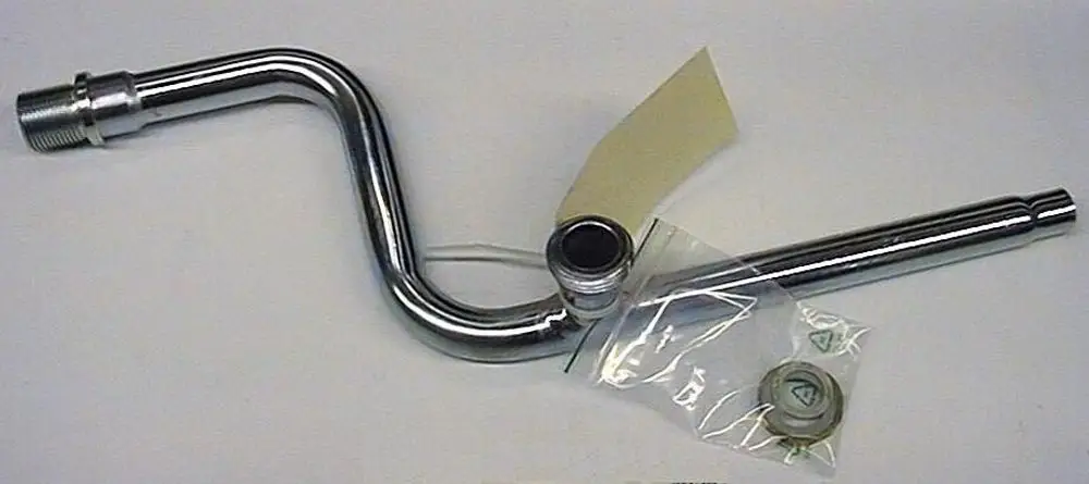 Brötje Vorlaufrohr mit einer gebogenen Metallstruktur, einem Anschluss auf der linken Seite und einem offenen Ende rechts, begleitet von Dichtungen in einer Plastiktüte.