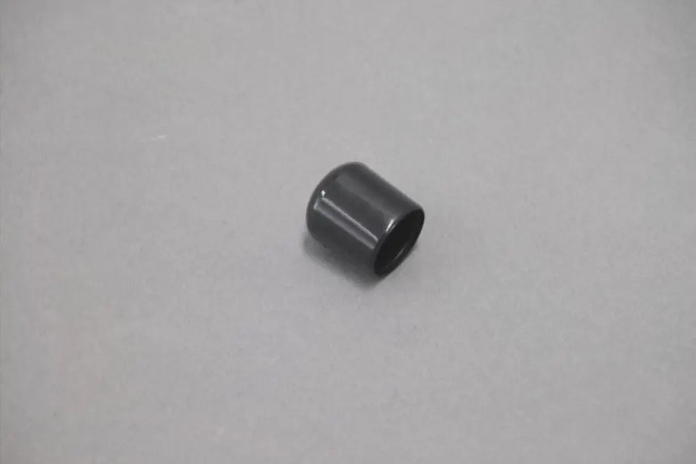 Schwarze, zylindrische Kappe für einen Siphon, wahrscheinlich von der Marke Brötje. Auf glattem Untergrund platziert.