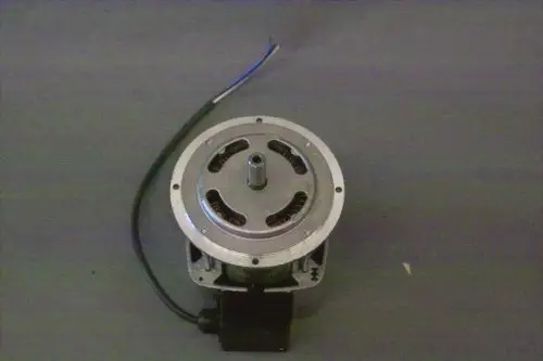 Brötje Gebläsemotor mit runder Gehäuseform und mehreren Lüftungsöffnungen, Kabelanschluss sichtbar auf der Oberseite. Die Unterseite hat eine Anschlusskomponente.