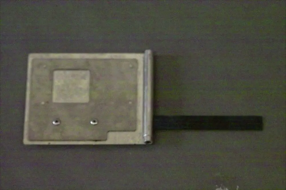 Brötje Luftklappe mit rechteckiger Metallplatte und einem beweglichen Teil an der Seite. Die Oberfläche ist schlicht und unbeschichtet.