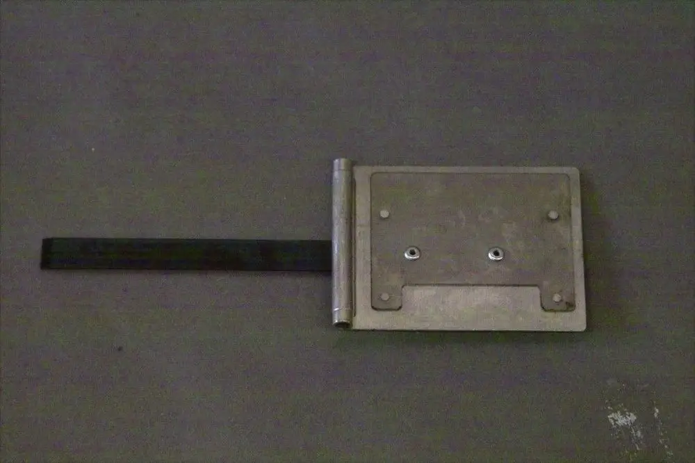 Brötje Luftklappe mit Metalloberfläche und seitlichem Hebelarm zur Betätigung. Die Klappe ist in einer flachen Ausführung mit zwei Befestigungslöchern dargestellt.