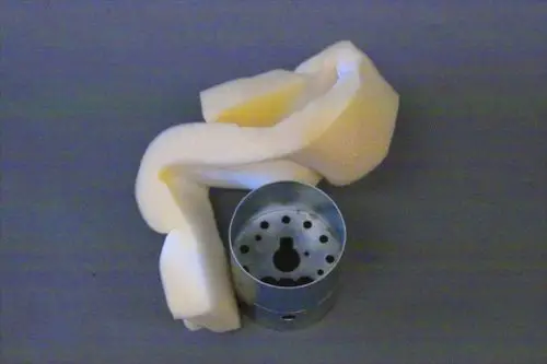 Brötje-Stauscheibe mit runder Metallbasis und gelochtem Design, umgeben von einem weißen Schaumstoffzuschnitt.