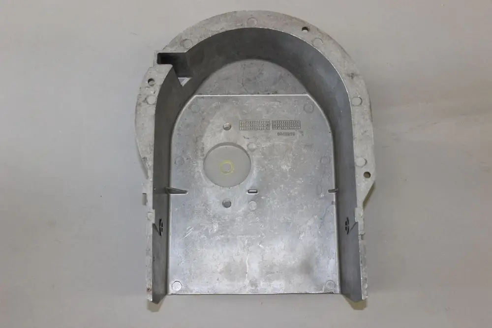 Metallisches Ansauggehäuse von Brötje, oval geformt mit einer runden Öffnung in der Mitte und mehreren Befestigungspunkten. Oberfläche weist leichte Gebrauchsspuren auf.
