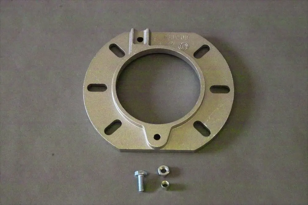 Brötje Kesselflansch aus Metall mit mittigem Loch und Befestigungslöchern, begleitet von einer Schraube und einer Unterlegscheibe.