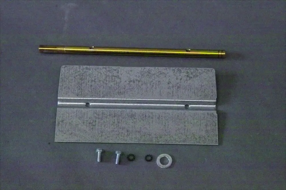 Montierte Teile für eine Brötje Luftklappe, bestehend aus einer Metallplatte, einer Stange, Schrauben und Unterlegscheiben in einer Übersicht auf grauem Untergrund.