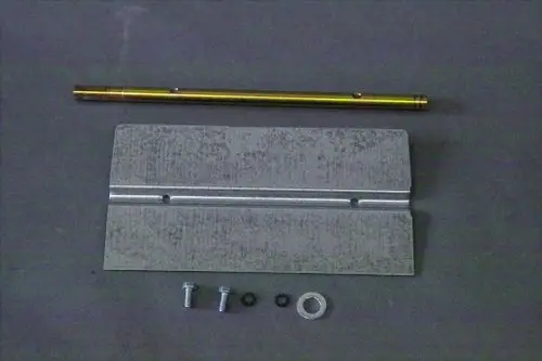 Montierte Teile für eine Brötje Luftklappe, bestehend aus einer Metallplatte, einer Stange, Schrauben und Unterlegscheiben in einer Übersicht auf grauem Untergrund.