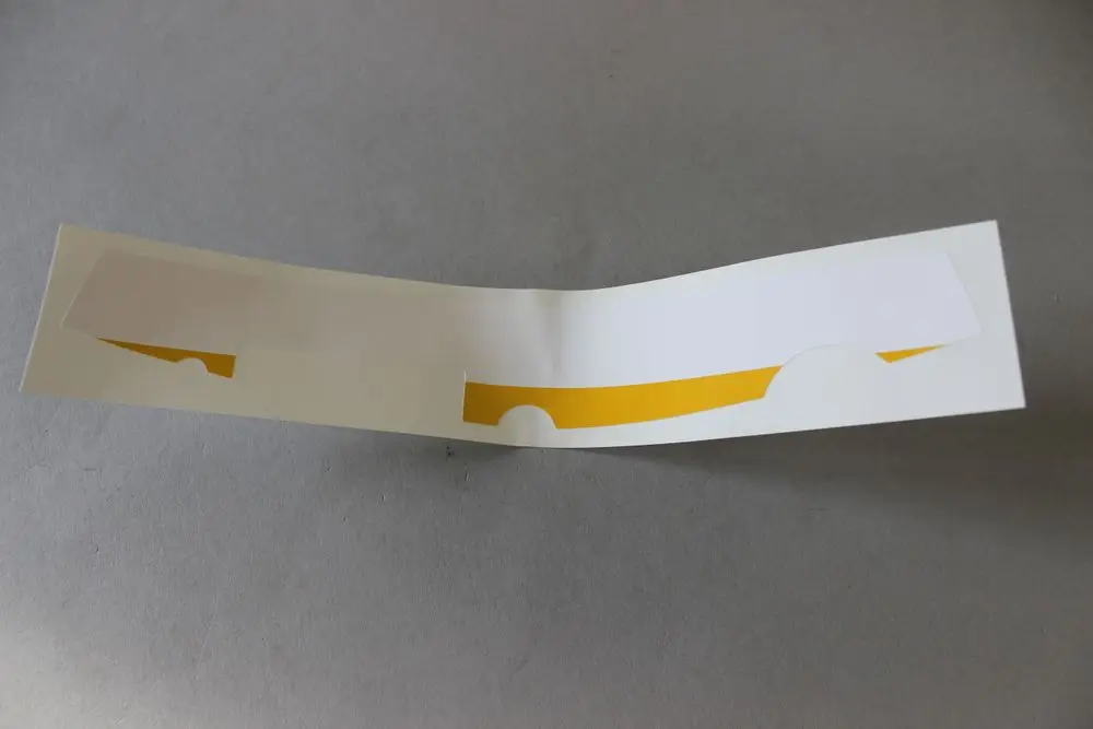 Brötje Schaltfeldfolie in weiß mit gelblichem Bereich, gefaltet, zeigt eine spezielle Struktur oder Form zur Verwendung in einem technischen Gerät oder System.
