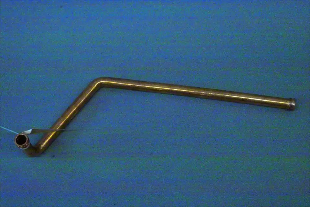 Brötje Rücklaufrohr aus Metall mit einem gebogenen Ende. Das Rohr hat eine Öffnung auf der einen Seite und eine gerade Fortsetzung auf der anderen Seite.