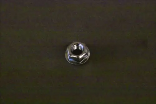 Brötje Mutter, metallisch, mit innerem Gewinde, auf dunklem Untergrund liegend.