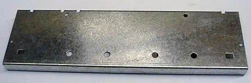Metallisches Rechteck mit mehreren Löchern und Aussparungen, vermutlich für die Montage. Teile der Struktur sind für einen Brötje Sockelrahmen erkennbar.