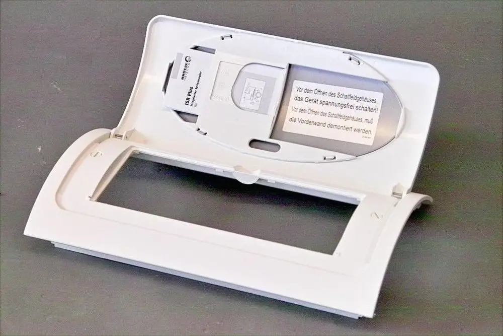 Weiße Abdeckung für eine Armatur, die im Inneren Platz für elektrische Komponenten bietet, mit einer Warnhinweis-Anleitung zur Spannungsfreischaltung vor dem Öffnen. Brötje Markenlogo sichtbar.