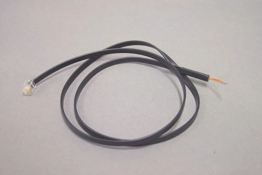 Schwarzes Kabel mit einem durchsichtigen Stecker an einem Ende und einem offenen Draht am anderen Ende, möglicherweise für Brötje Produkte verwendet.