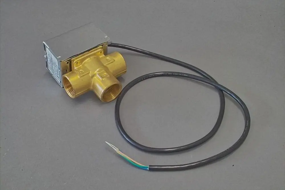 Brötje 3-Wege-Ventil mit einem elektrischen Anschlusskabel. Das Gehäuse ist aus Messing, mit drei Anschlussmöglichkeiten für Flüssigkeitsleitungen.