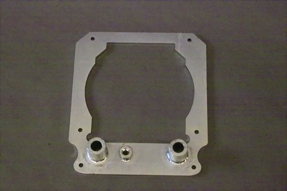 Aluminium Halteblech von Brötje mit rechteckigem Ausschnitt und zwei Anschlüssen. Die Oberfläche ist glatt und in Metall-Optik gehalten.