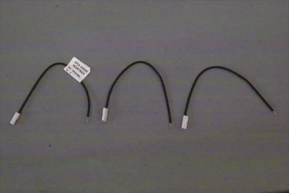 Drei Brötje Anschlusskabel mit unterschiedlichen Enden. Auf einem Kabeletikett sind Informationen aufgedruckt. Die Kabel sind schwarz und haben weiße Steckverbindungen.