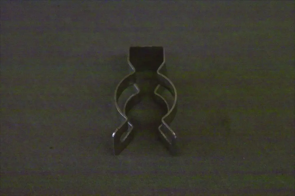 Brötje Klemme für Schnellverbindung, aus Metall, mit zwei u-förmigen Haltepositionen und einer oberen Befestigung, auf schwarzem Hintergrund.