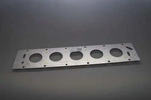 Metallische Platte mit mehreren runden Ausschnitten und Befestigungslöchern, wahrscheinlich Teil eines Heizsystems der Marke Brötje.
