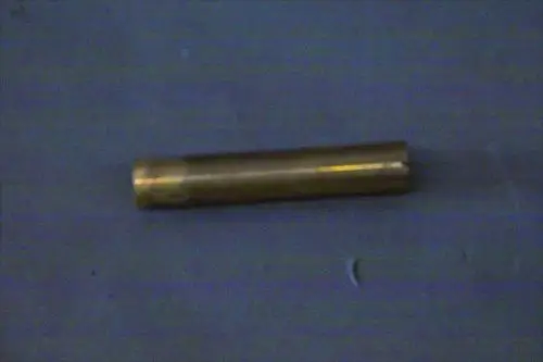 Ein zylindrischer, messingfarbener Metallkörper, möglicherweise ein Verbindungselement, liegt auf einer blauen Oberfläche. Er könnte Bestandteil eines Brötje-Heizsystems sein.