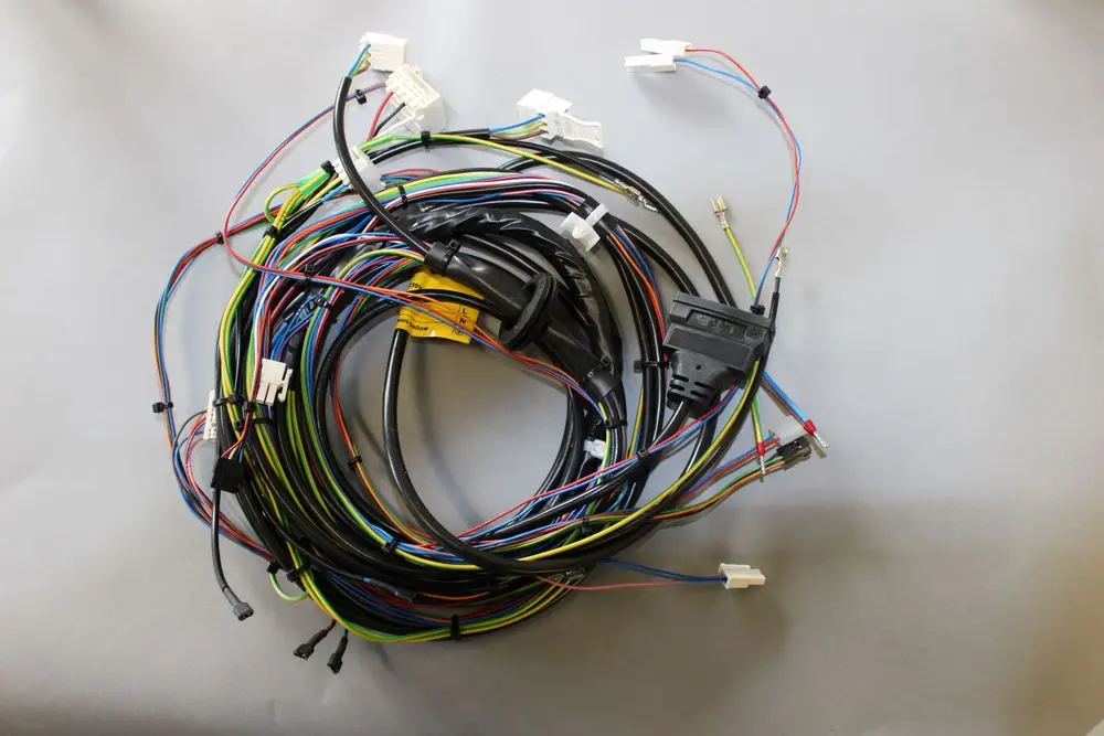 Kabelbaum mit mehreren bunten Leitungen und Steckverbindungen, der für Brötje Produkte verwendet wird. Die Kabel sind verwickelt und auf einer grauen Unterlage angeordnet.