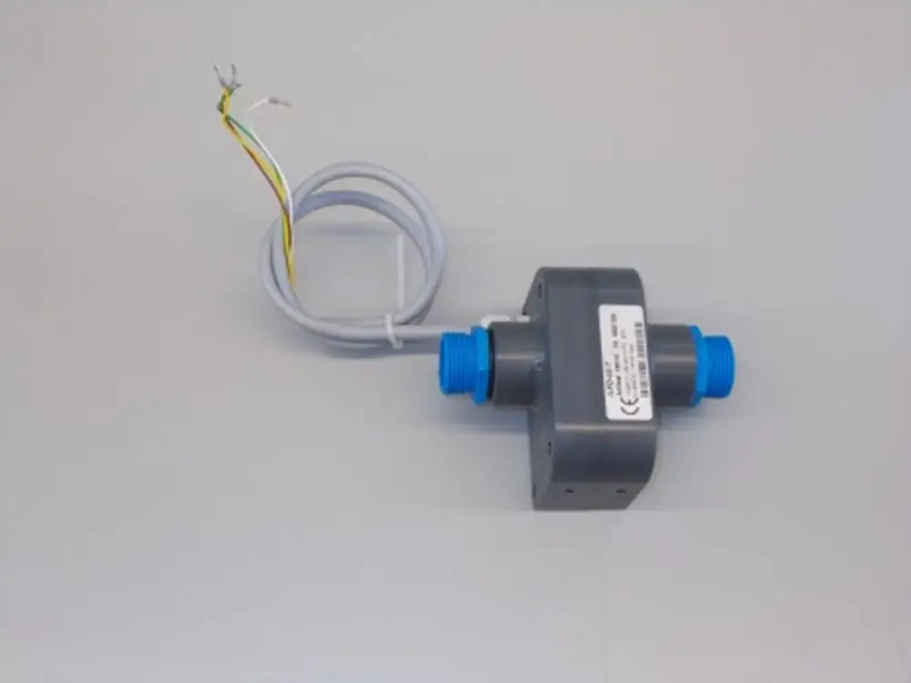 Graue Baugruppe mit zwei blauen Anschlüssen und einem Kabel mit drei Leitungen. Produkt von Brötje, verarbeitet für die Verwendung in Heizungs- oder Flüssigkeitssystemen.