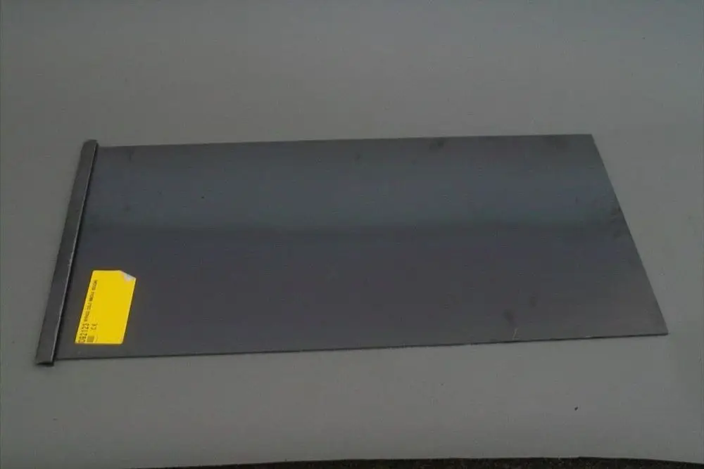 Graues Metallblech mit einer geraden Kante und einem Aufkleber, möglicherweise zur Verwendung in Heizsystemen von Brötje.