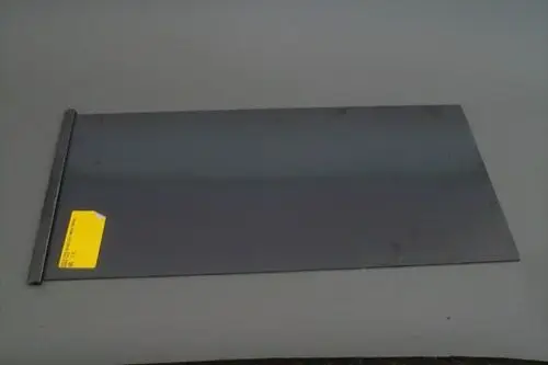 Graues Metallblech mit einer geraden Kante und einem Aufkleber, möglicherweise zur Verwendung in Heizsystemen von Brötje.