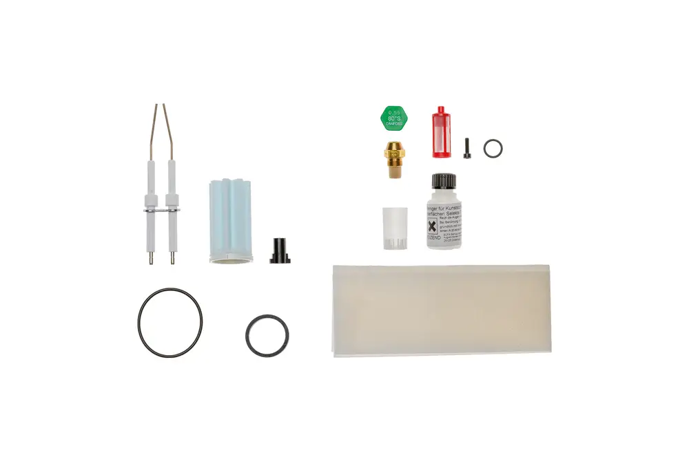 Wartungsset von Brötje mit verschiedenen Komponenten wie Elektroden, Dichtungen, Ventilen und einer Flasche Öl, angeordnet auf einem weißen Hintergrund.