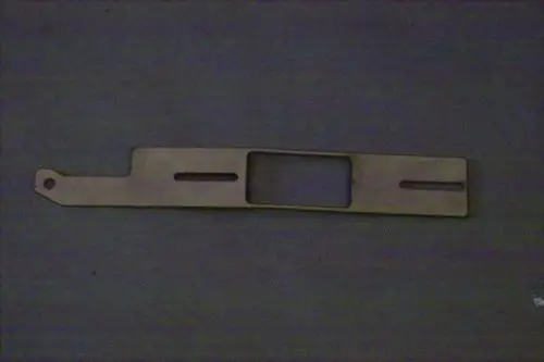 Luftschieber von Brötje, längliche Metallplatte mit Ausschnitten und einer Öse, liegt auf einer dunklen Oberfläche.