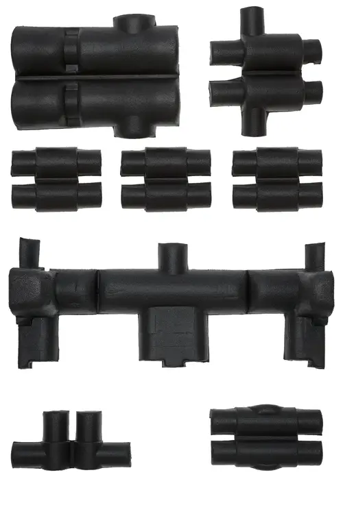 Diverse schwarze Isolierformteile von Brötje, in unterschiedlichen Größen und Formen angeordnet, zur Verwendung in Heizungsanwendungen.