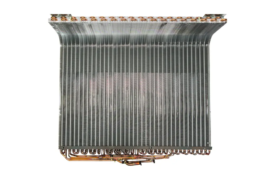 Brötje Verdampfer/Kondensator mit mehreren Kupferrohren und lamellenförmigen Kühlrippen, sichtbar auf einer metallischen Oberfläche.