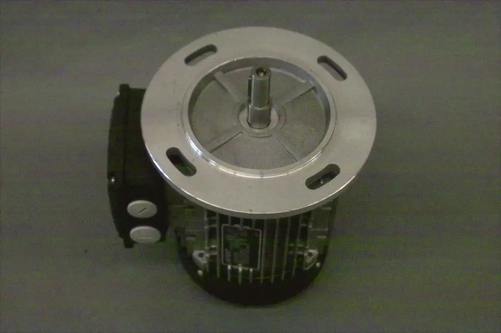 Brötje Motor mit runder, metallischer Oberflächenplatte und einem hervorstehenden Antriebszahnrad, seitlich montiert ein schwarzes Gehäuse mit zwei Druckknöpfen.