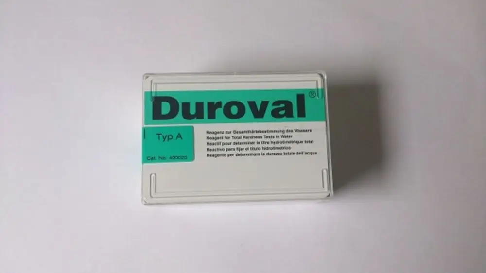 Testkit von Brötje zur Bestimmung der Gesamtwasserhärte. Verpackt in einem klaren Behälter mit grünem Aufkleber und mehrsprachigen Anweisungen für die Anwendung.