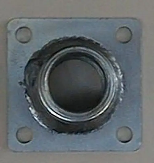 Metallischer Düsenhalter mit quadratischer Grundplatte und zentralem Gewinde, geeignet für Brötje Heizsysteme. Vier Montagelöcher für Befestigung sichtbar.