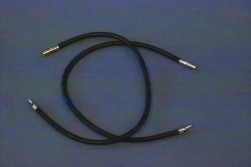Schwarze Kabel mit Metallanschlüssen, die typisch für Zündleitungen sind, möglicherweise von der Marke Brötje. Sie liegen übereinander auf einer grauen Unterlage.
