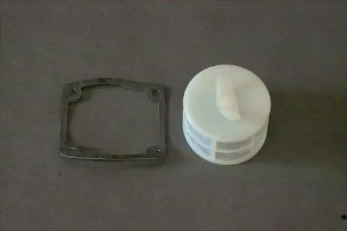 Brötje Pumpenfilter und Dichtung in zwei Teilen, der Filter hat eine runde Form mit horizontalen Rillen, die Dichtung ist rechteckig mit abgerundeten Ecken und Bohrungen.