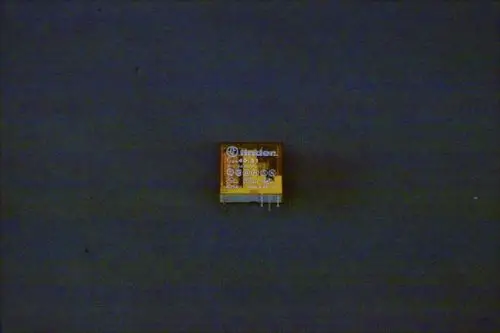 Brötje Relais auf grauem Hintergrund, mit mehreren Anschlussstiften. Das Produkt zeigt Symbole und eine Typenbezeichnung auf der Oberseite.