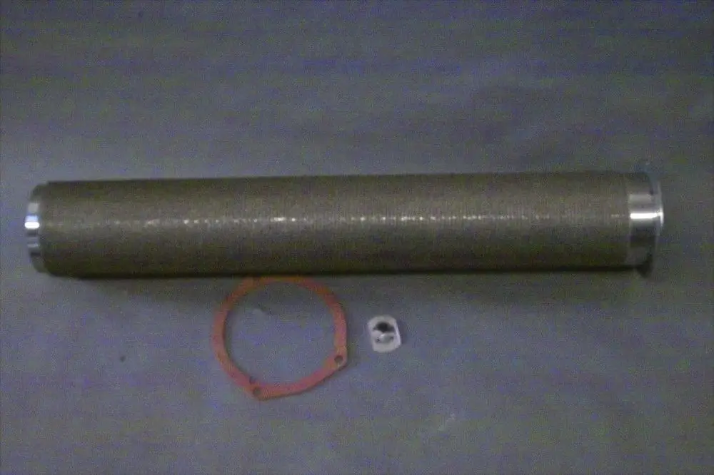 Brötje Brennerrohr in zylindrischer Form, ausgekleidet mit einem Gittermuster. Zusätzlich sind Dichtungsring und eine kleine Metallplatte zu sehen.