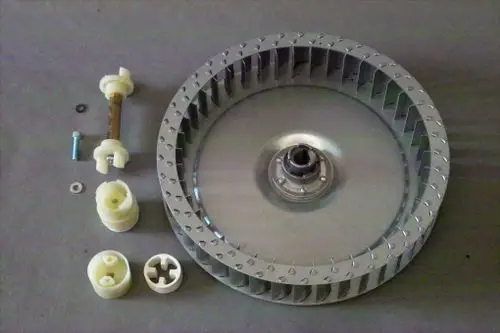 Brötje Gebläserad mit metallischer Oberfläche und mehreren Lüftungsschaufeln, begleitet von Kunststoffteilen und einer Schraube. Teile scheinen für ein Heizsystem konzipiert zu sein.
